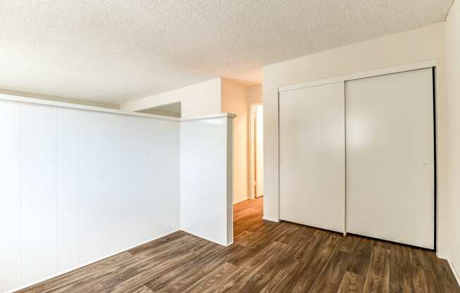 an empty living room with white walls and wood flooring