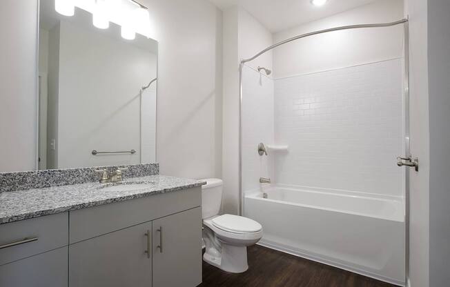A white bathroom with a toilet, sink, and bathtub.