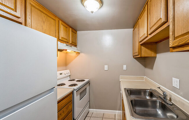 a kitchen with a stove refrigerator and sink