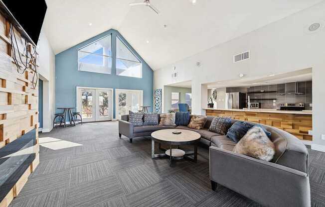 A modern living room with a grey couch and a round coffee table.