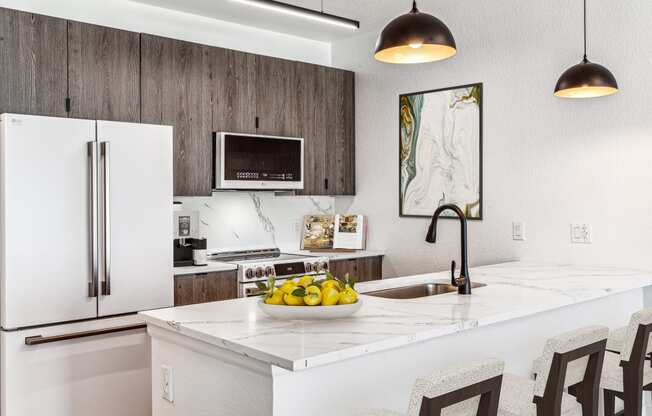 a kitchen with a white counter top with a bowl of fruit