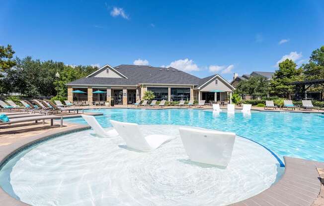 A large outdoor swimming pool with a hot tub in the middle.