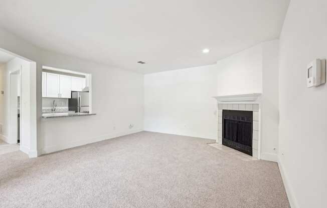 A living room with a fireplace and a carpet.