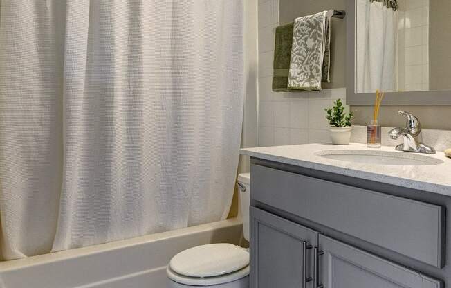 a bathroom with a white shower curtain and a toilet and a sink