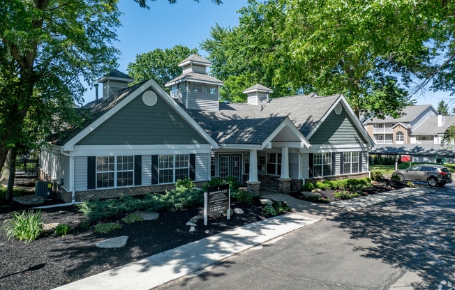 the front of a house with a sidewalk and trees