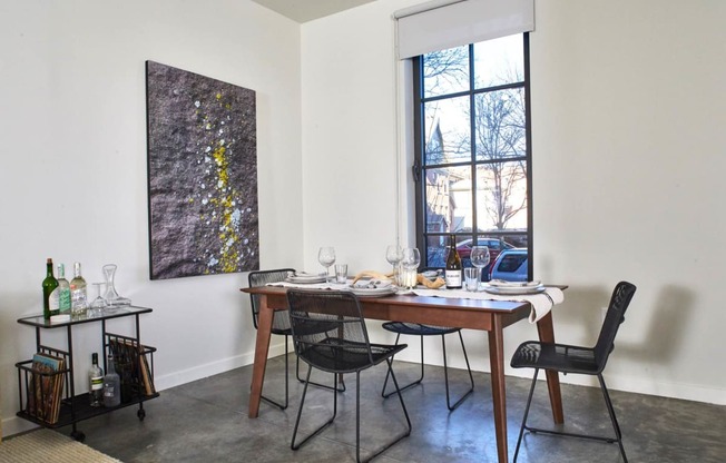 a dining room with a table and chairs and a window