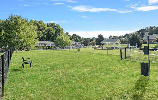 a park with a fence and benches in the grass
