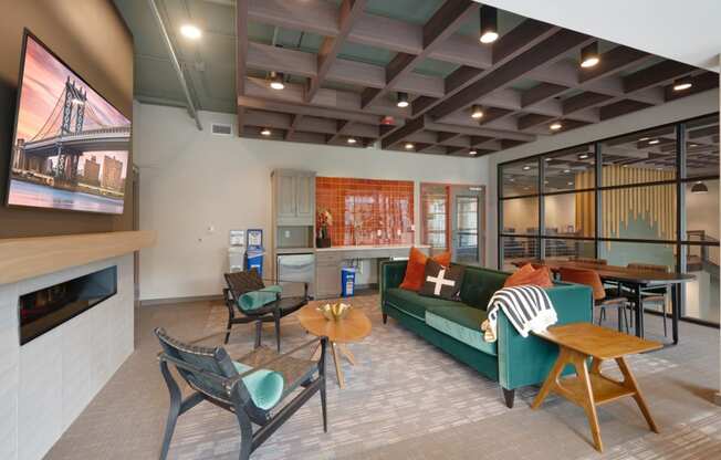 a living room with a green couch and chairs and a television