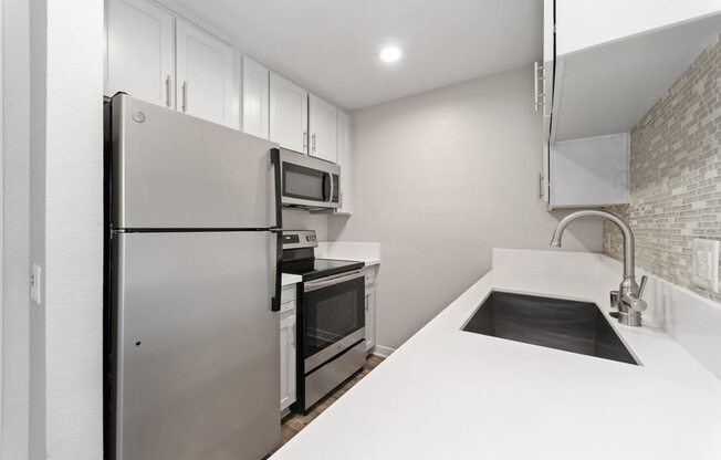 modern kitchen with stainless steel appliances at Pointe Luxe Apartment Homes, San Diego, CA, 92110