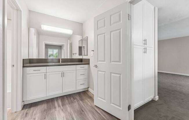 A white kitchen with a large door and a window.