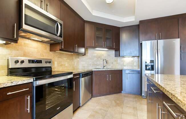 A kitchen with brown cabinets and stainless steel appliances.
