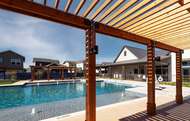 a swimming pool with a wooden structure in front of a house