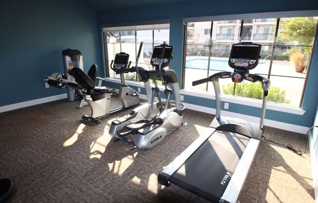 This is a photo of the fitness center showing workout machines at Woodbridge Apartments in Dallas, TX.