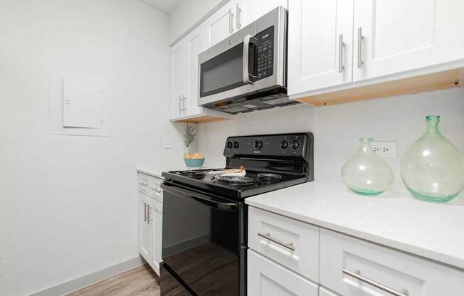 A black stove top oven with a black microwave above it.