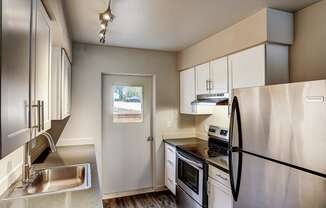 a kitchen with stainless steel appliances and white cabinets at Woodcreek, Poulsbo, WA