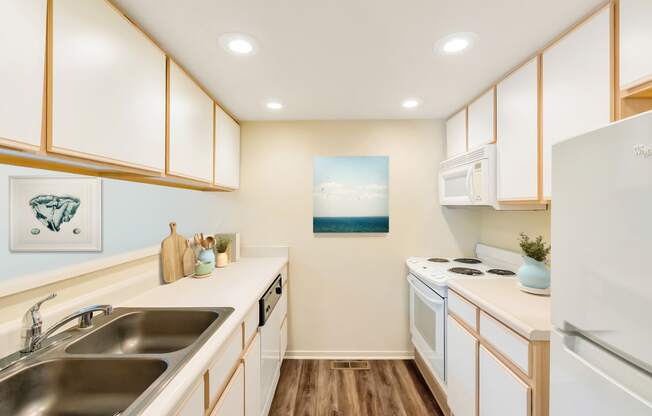 a kitchen with white appliances and wooden cabinets and a sink