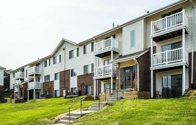 a photo of a row of apartment buildings on a grassy hill