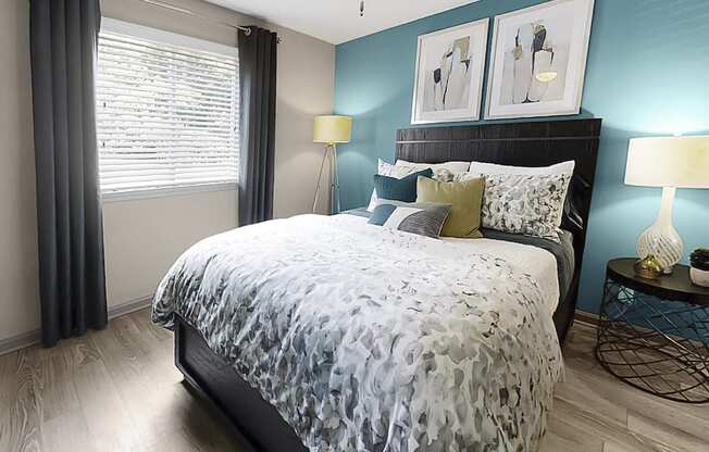 Bedroom with large window, plank-style floor, and model furnishings at The Madison Franklin, Tennessee