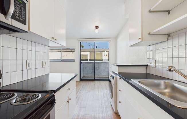 A kitchen with black countertops and white cabinets.