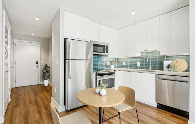 A modern kitchen with a table and chairs.