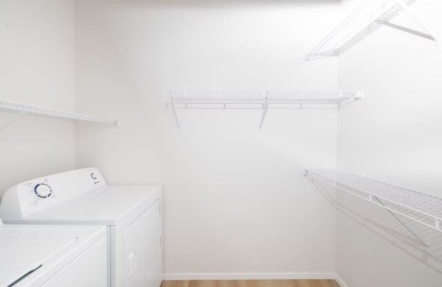 A white laundry room with a washer and dryer.