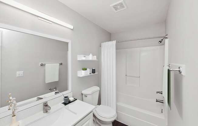 Model Bathroom with White Cabinets, Wood-Style Flooring and Shower/Tub at Vue at Baymeadows Apartments in Jacksonville, FL.