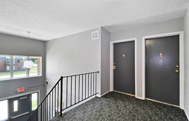 A hallway with two doors and a staircase.