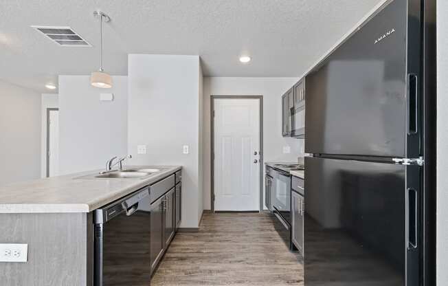 Modern open-concept kitchen and living area with black appliances.