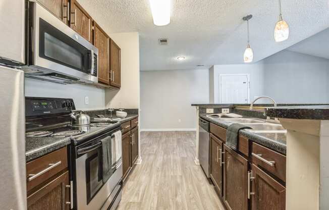 an open kitchen with stainless steel appliances and wooden cabinets