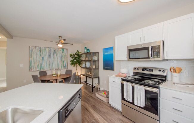 a kitchen with white cabinets and stainless steel appliances