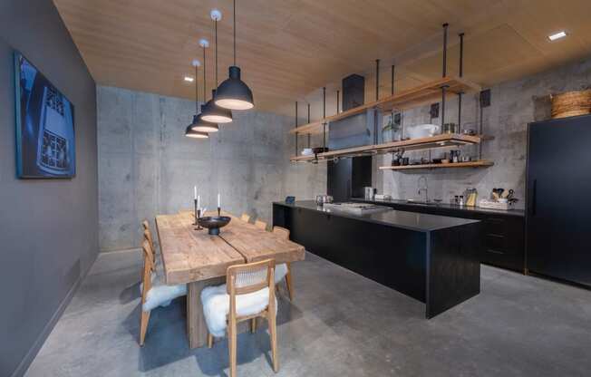 a kitchen with a wooden table and black cabinets at The Audubon New Haven, New Haven
