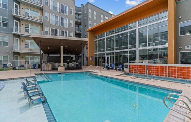 a swimming pool with a large building in the background