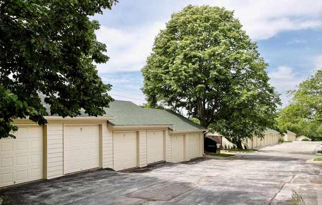 A row of garage doors are closed and the sky is blue.