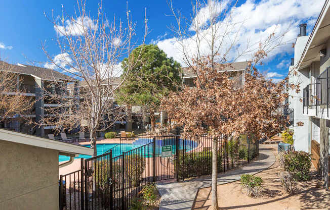 A pool surrounded by a fence and trees.