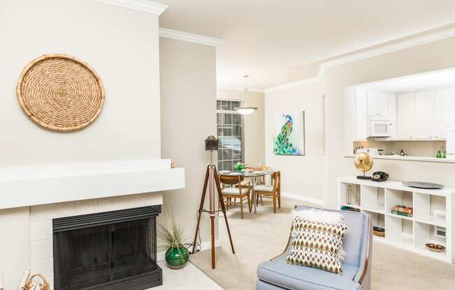 a living room with a fireplace and a table with a chair