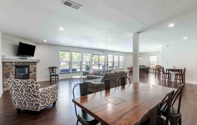 the gathering room has a large table with chairs and a fireplace