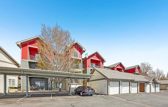 A parking lot in front of a building with a car parked.