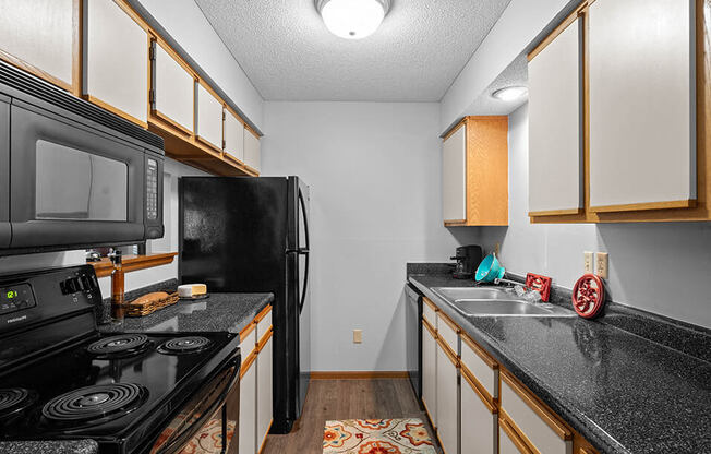 a kitchen with black appliances and granite counter tops