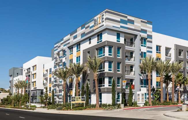 A modern multi-story building with a white facade and blue and yellow accents.