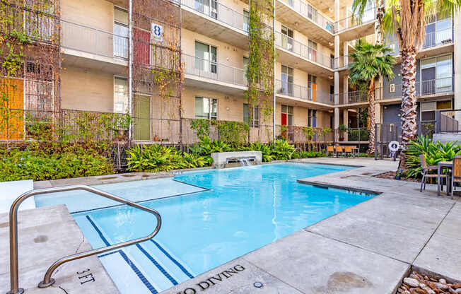 A pool surrounded by apartment buildings with a "No Diving" sign.