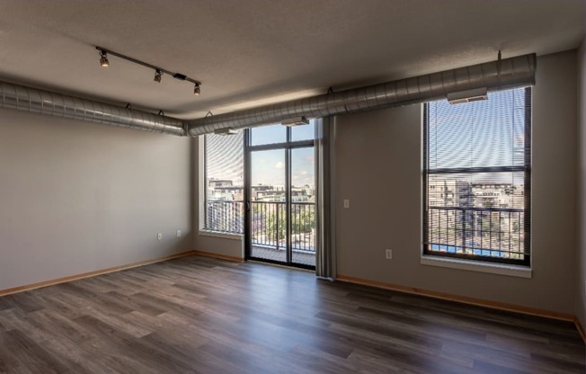 An open living room with a sliding glass door leading to a balcony.