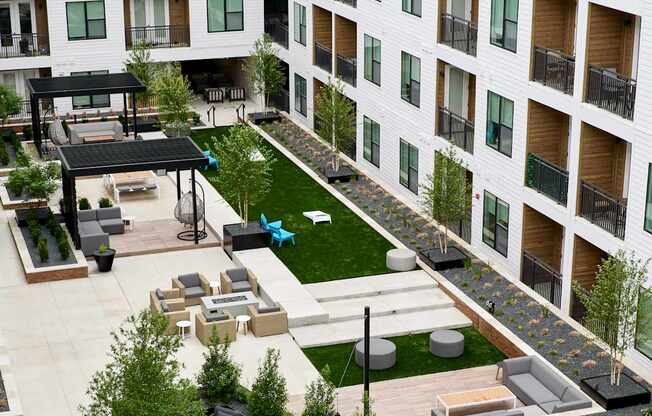 A large atrium with a green lawn and trees in the middle of a building.