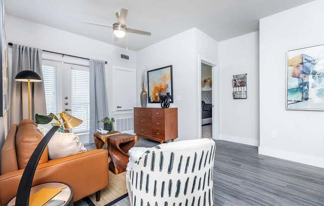A living room with a brown leather chair and a white ottoman.