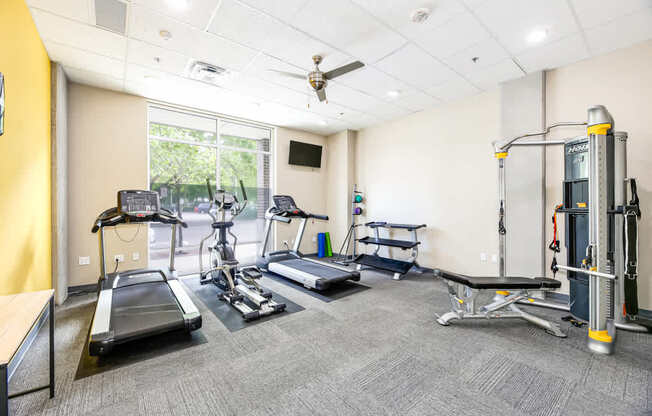 A gym with treadmills, elliptical machines, and other exercise equipment.