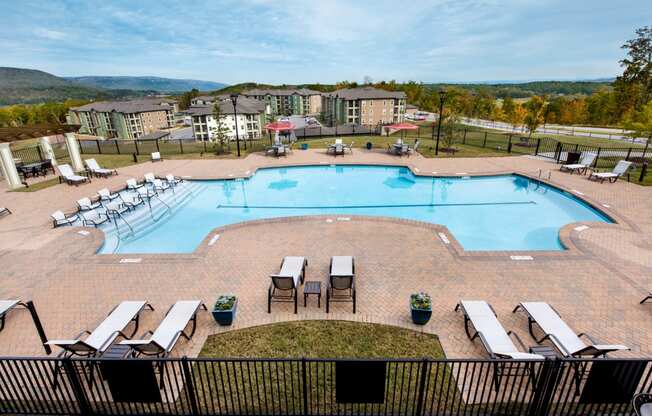 an aerial view of an outdoor pool with chairs