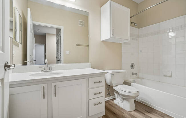 A white bathroom with a toilet, sink, and bathtub.