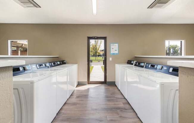 a row of washers and dryers in a laundry room