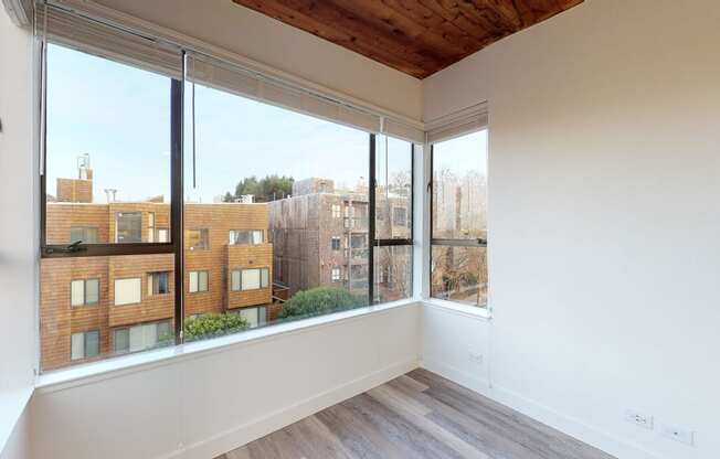 a bedroom with a large window and a wooden ceiling