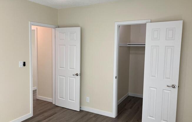 A room with two white doors, one of which is open.