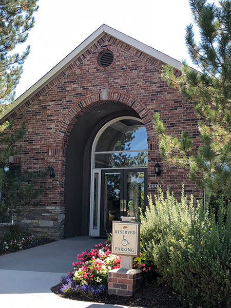 Westlake Greens Leasing Office brick front entrance with green plants and flowers